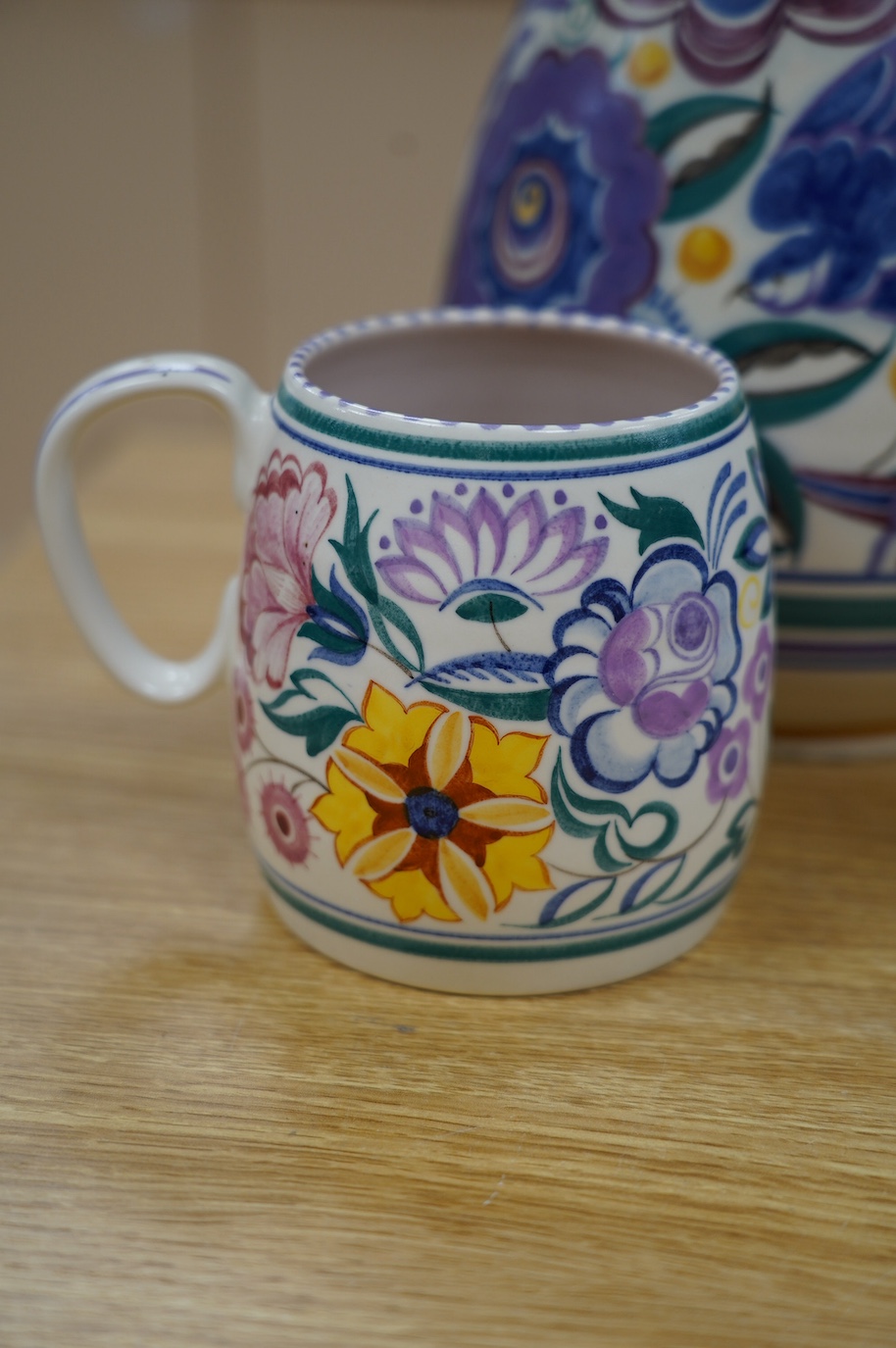 A 1930’s Poole pottery vase and a later mug, vase 25cm high. Condition - fair slight grazing to base rim of vase